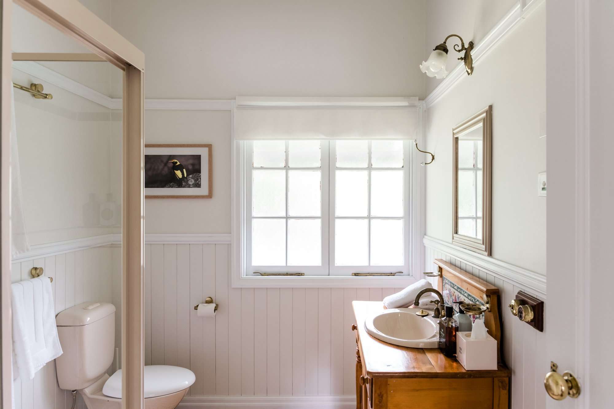 Beautiful bathroom setup with wall art and complimentary toiletries, attached to the Bowerbird Cottage on Mount Glorious, Queensland