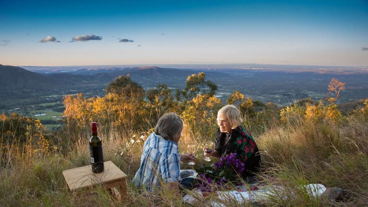 On the mountain - An image of a mature couple having a drink at Jollys Lookout_Moreton Bay Region
